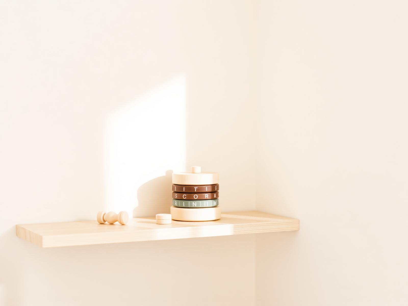 Minimal wooden baby toys on a nursery shelf
